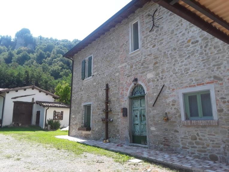 un grande edificio in pietra con una porta verde di All'Ovile a Montevescovo