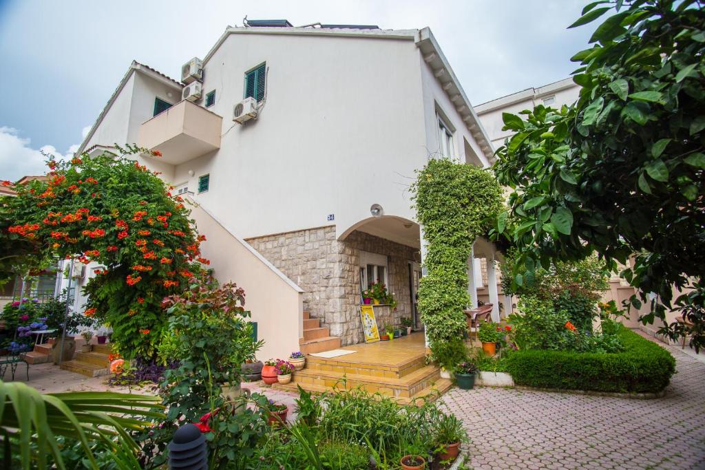 ein Gebäude mit einem Innenhof mit Blumen und Pflanzen in der Unterkunft Rooms & Apartments Boskovic in Budva