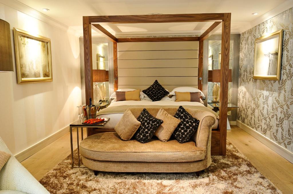 a bedroom with a large bed and a couch at Grosvenor Pulford Hotel & Spa in Pulford