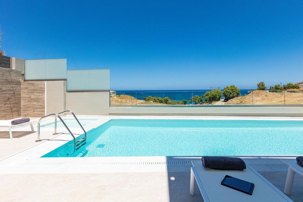 a swimming pool with a view of the ocean at Lagoon Seaside Villa, Sumptuous Retreat,By ThinkVilla in Panormos Rethymno