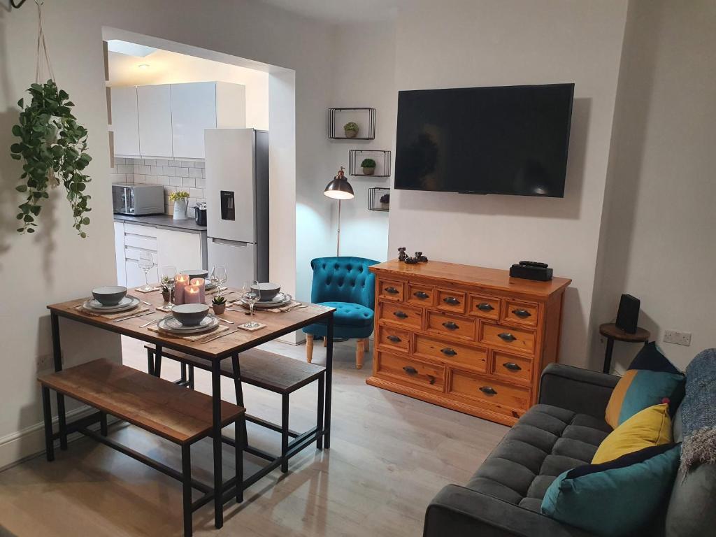 a living room with a table and a kitchen at Victoria House - 3 Bedrooms, 3 Bathrooms by Cliftonvalley Apartments in Bristol