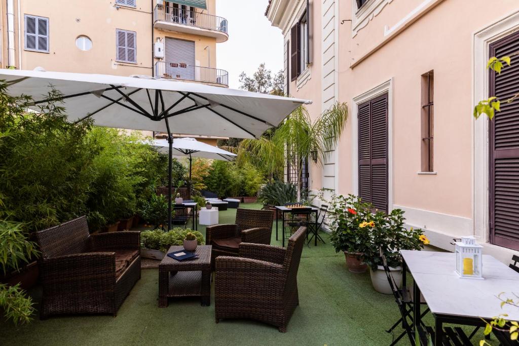 an outdoor patio with chairs and an umbrella at Hotel Coppede' in Rome