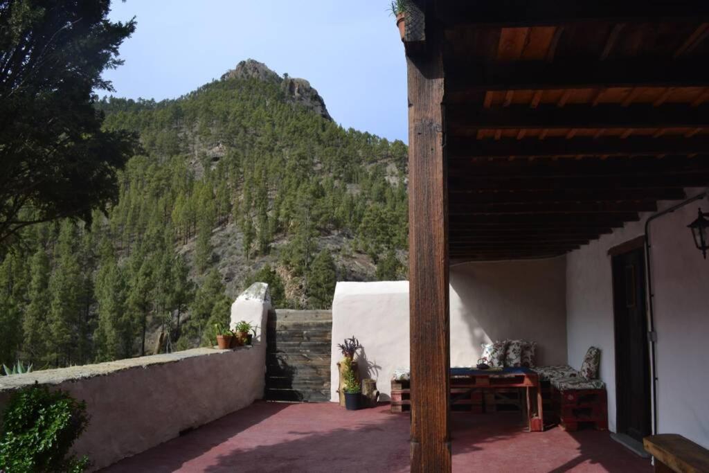 a patio with a table and chairs and a mountain at Casa Rural Lomito del Pino in Tejeda