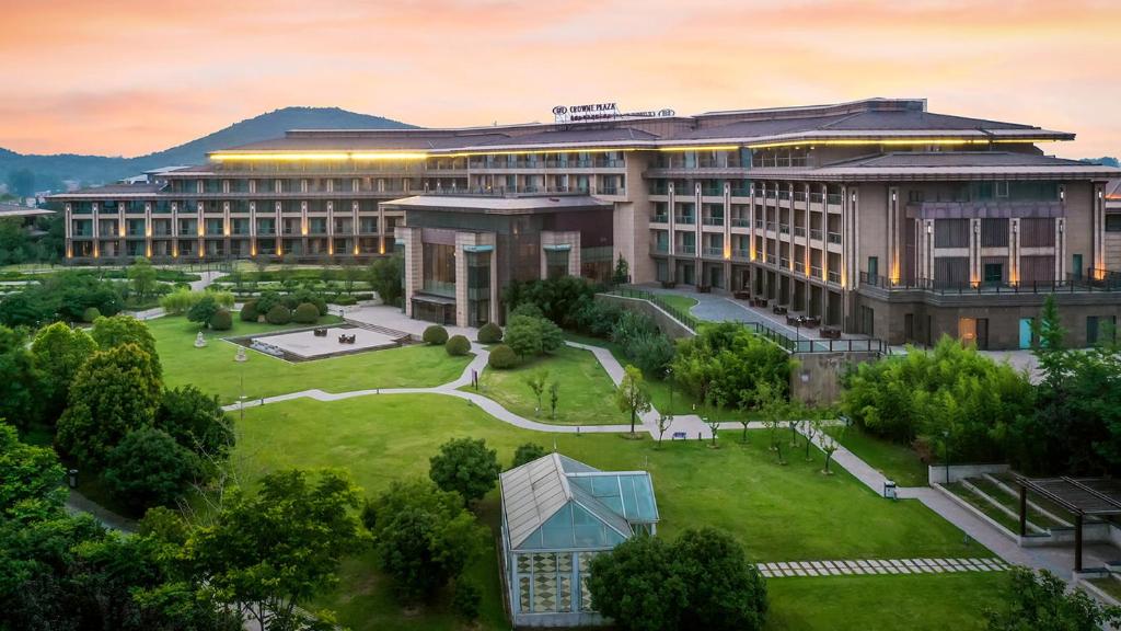 un edificio de oficinas con un parque delante de él en Crowne Plaza Xuzhou Dalong Lake, an IHG Hotel, en Xuzhou