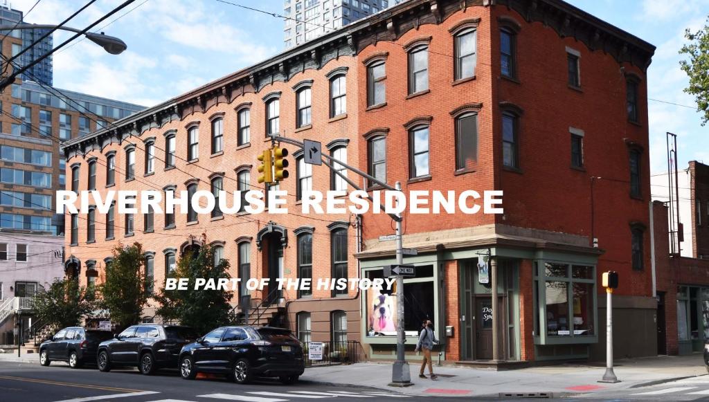 un gran edificio de ladrillo con un cartel. en Riverhouse Extended Stay Apartment, en Jersey City