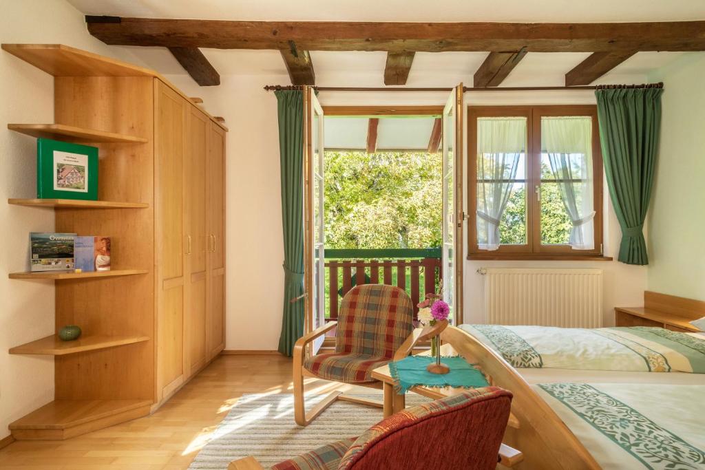 a bedroom with a bed and a chair and a window at Ferienwohnung Risthof 2 in Owingen