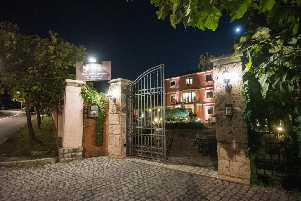 a gate to a building at night at The Belgrade Hills Rooms and Suites in Belgrade