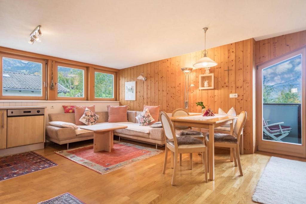 uma sala de estar com um sofá e uma mesa em Försterhaus Wohnung Dachgeschoss em Egg