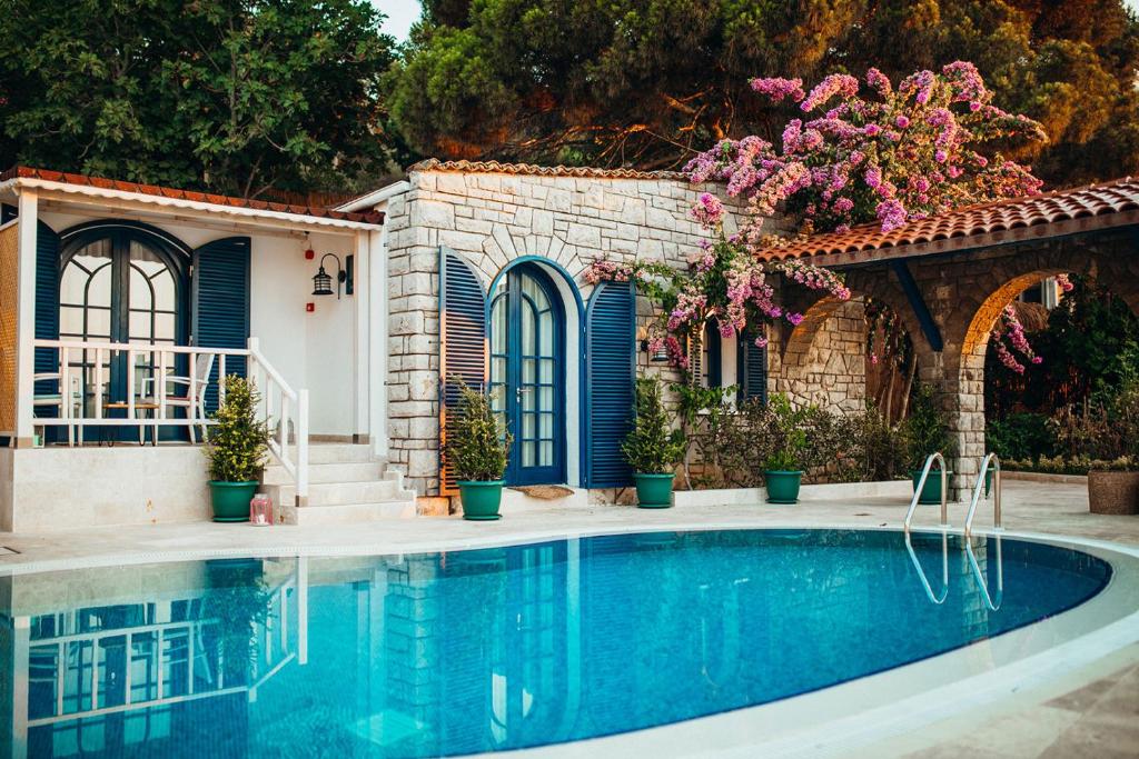 a swimming pool in front of a house with flowers at Büyükada Loc'ada in Adalar