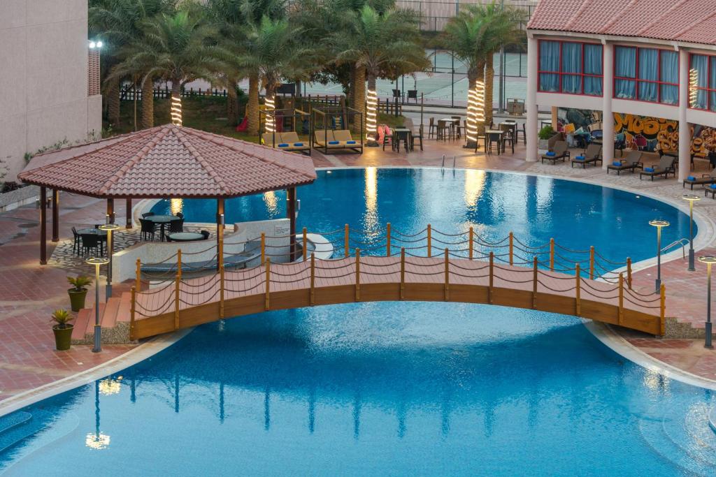 a swimming pool with a pool table and chairs at Alreem Village Hotel in Al Jubail