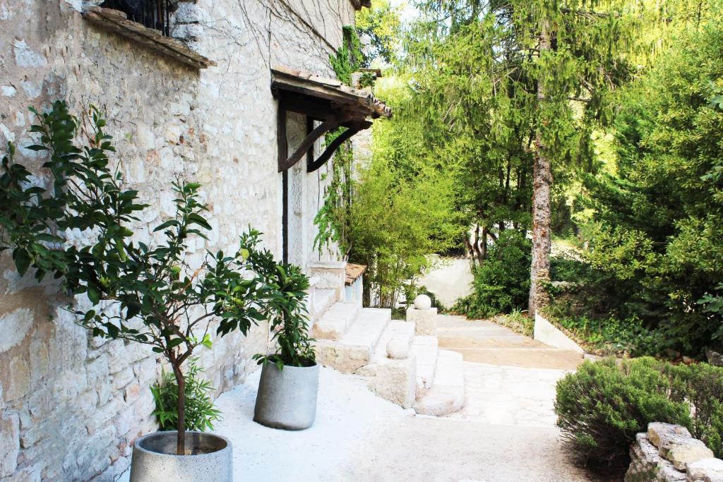 un giardino con alberi in vasi accanto a un edificio di Le Mas Des Alizés a La Colle-sur-Loup