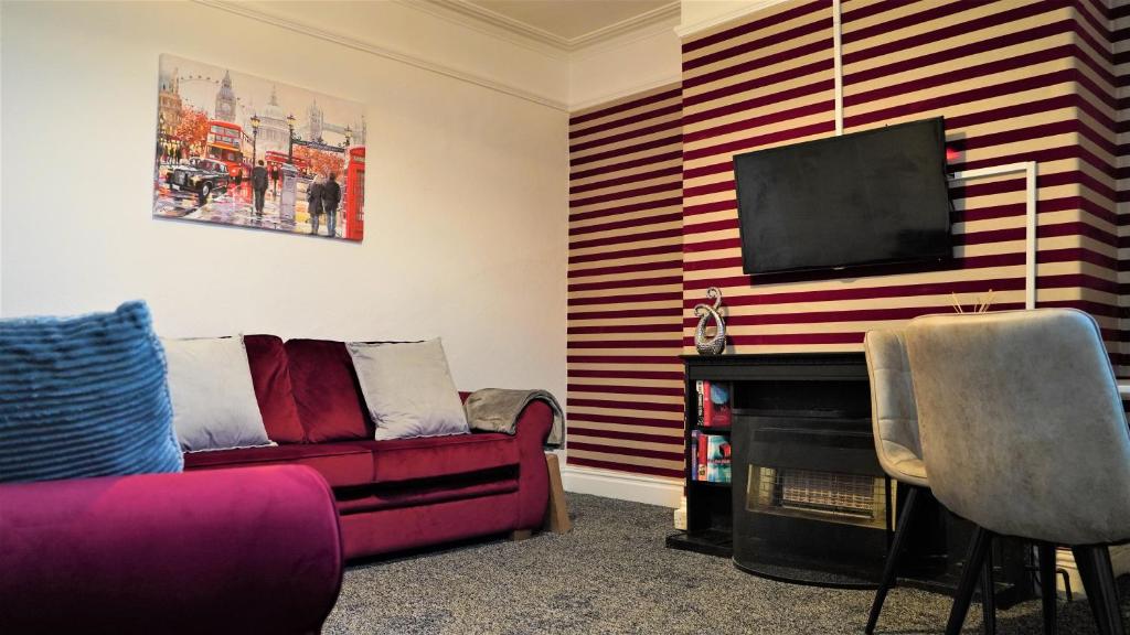 a living room with a couch and a flat screen tv at Dean House in Leeds
