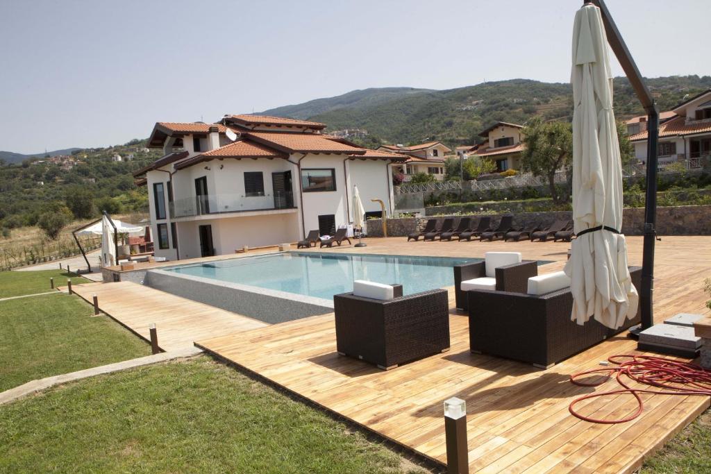 a villa with a swimming pool and an umbrella at Villa Mediterraneo in Fuscaldo
