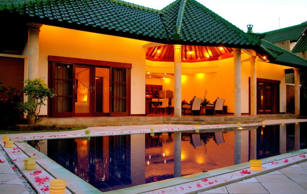 a house with a swimming pool in front of a house at Bali Emerald Villas in Sanur