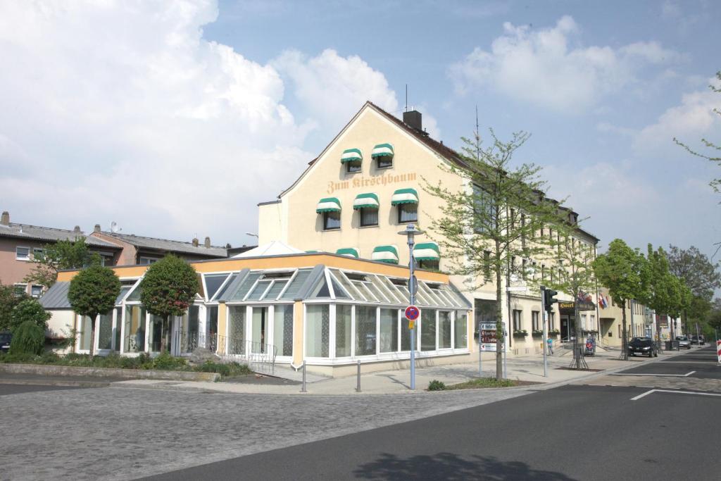 een wit gebouw met ramen aan een straat bij Hotel-Restaurant Zum Kirschbaum in Rottendorf