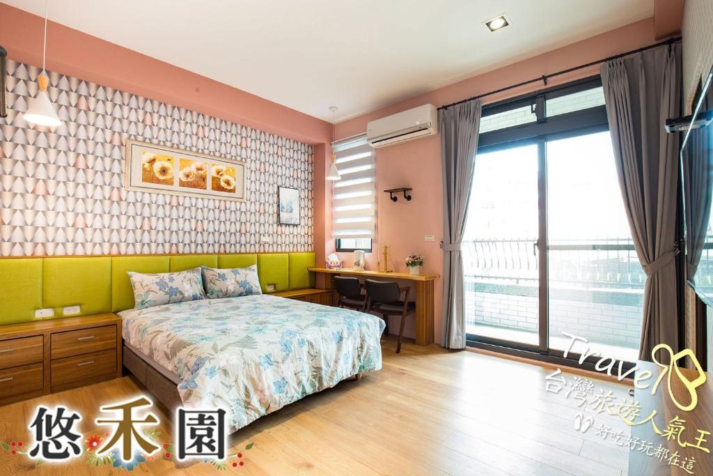 a bedroom with a bed and a desk and a window at Host Garden悠禾園 in Hualien City
