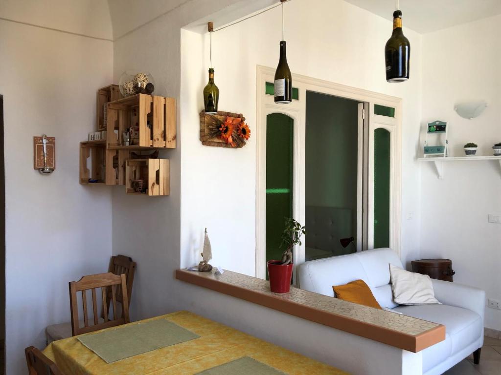 ein Wohnzimmer mit einem weißen Sofa und einem Tisch in der Unterkunft Appartamento Arte e Mare in Bordighera