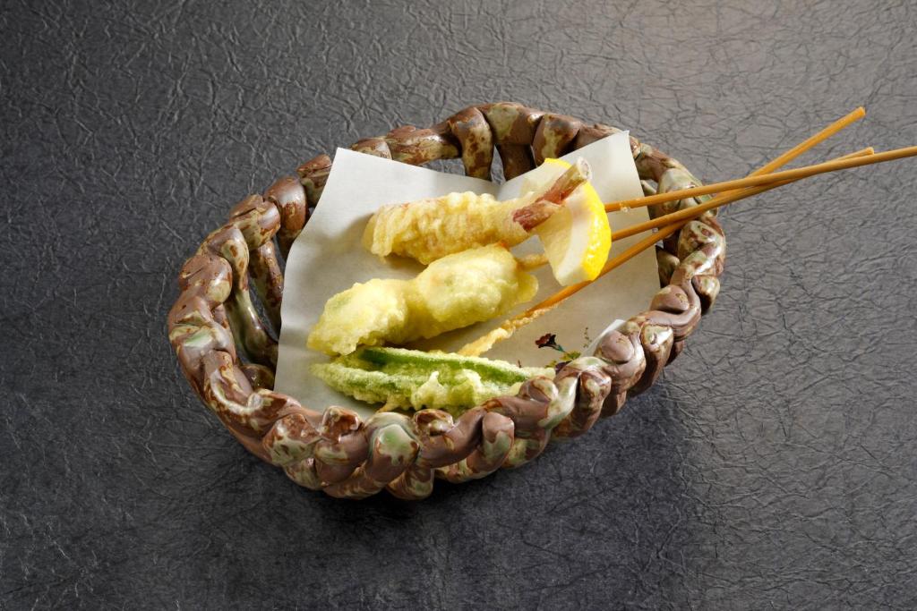 a plate of food with chopsticks on a table at Wafu-no-Yado MASUYA in Yamanouchi