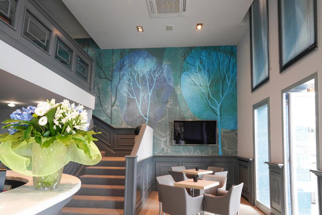a restaurant with a mural of trees on the wall at Sole Mare in Ventimiglia