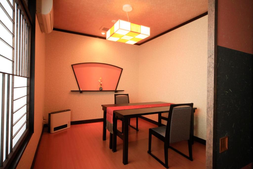 a dining room with a red table and chairs at Wafu-no-Yado MASUYA in Yamanouchi