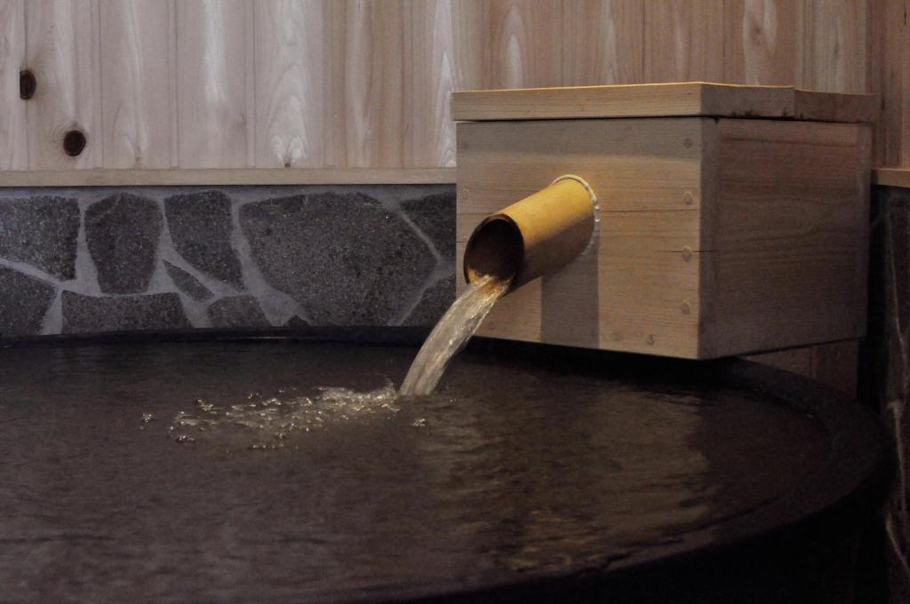a pipe pouring water into a bird house at Wafu-no-Yado MASUYA in Yamanouchi
