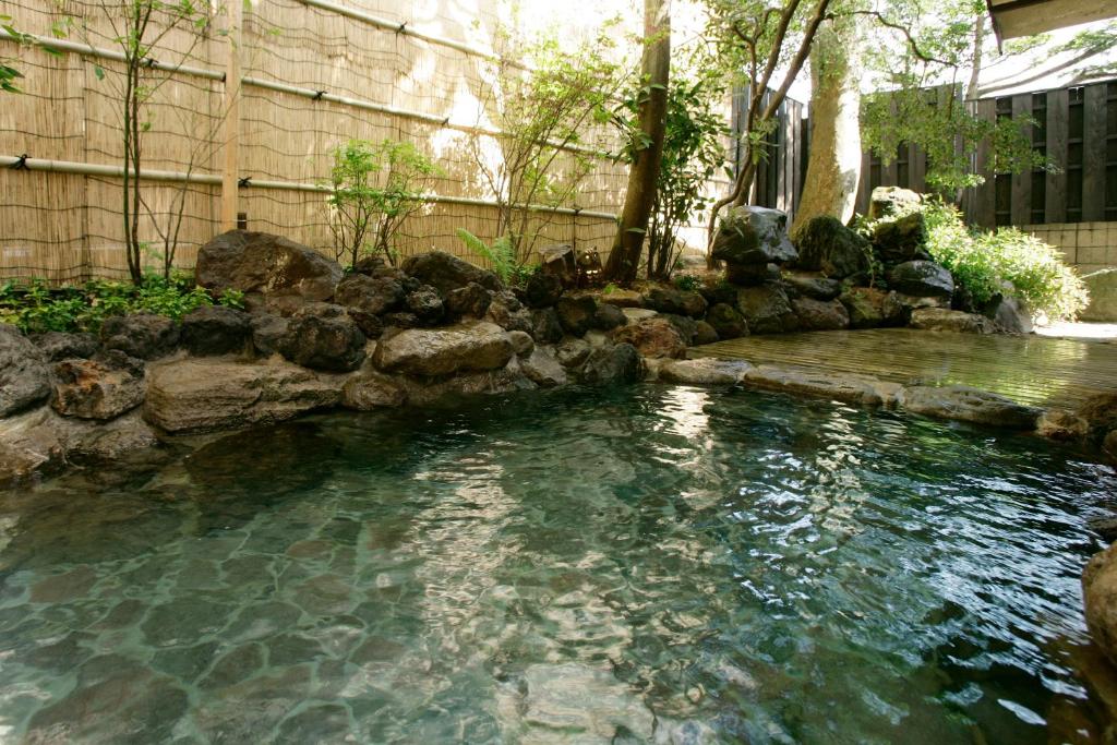 a pool of water with rocks in a yard at Wafu-no-Yado MASUYA in Yamanouchi