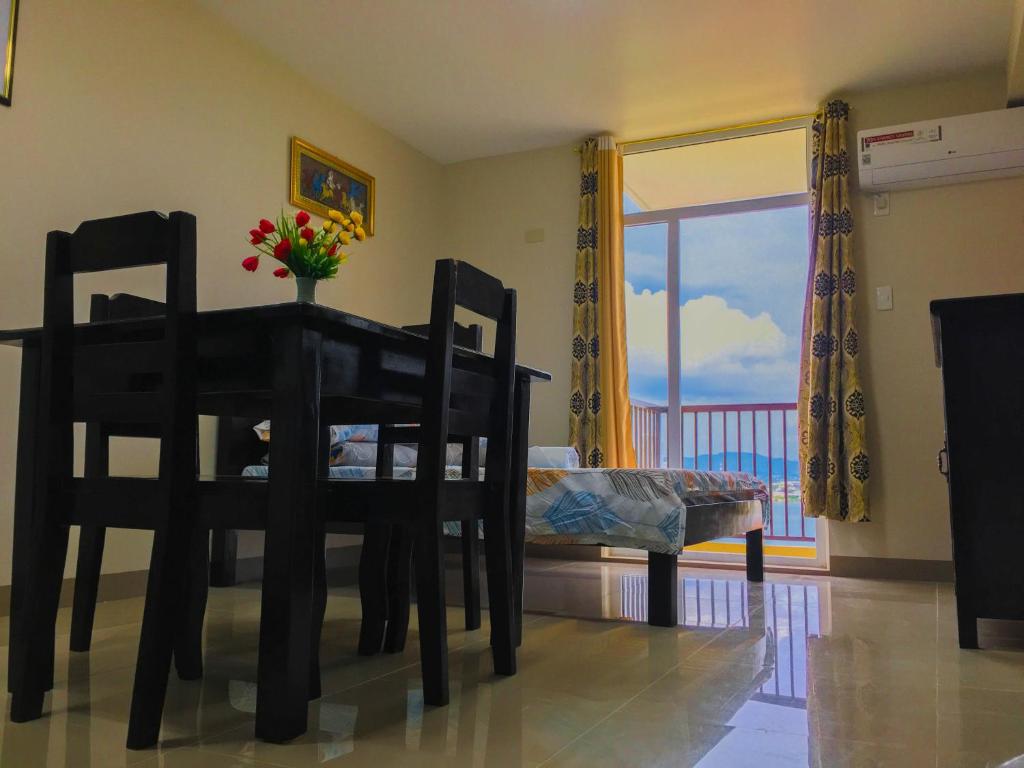 Gibzon's Invitation Suites near Mactan airport في ماكتان: غرفة طعام مع طاولة وكراسي ونافذة