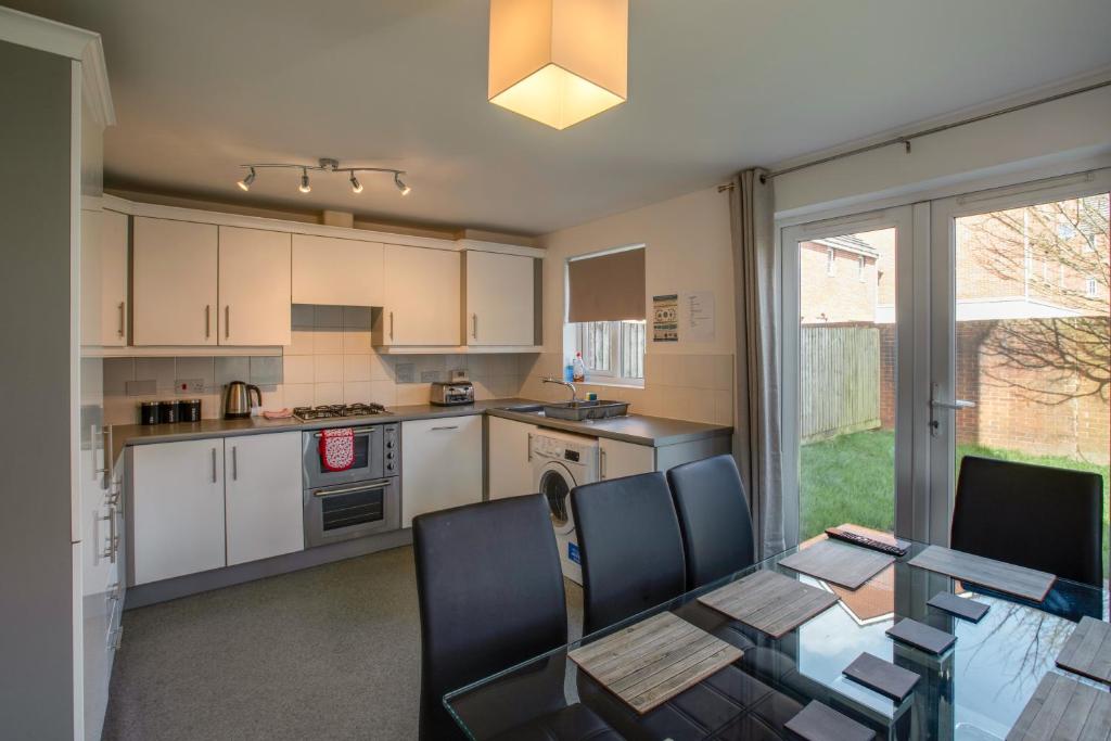 a kitchen with a table and chairs and a dining room at Watkins House by Cliftonvalley Apartments in Cardiff