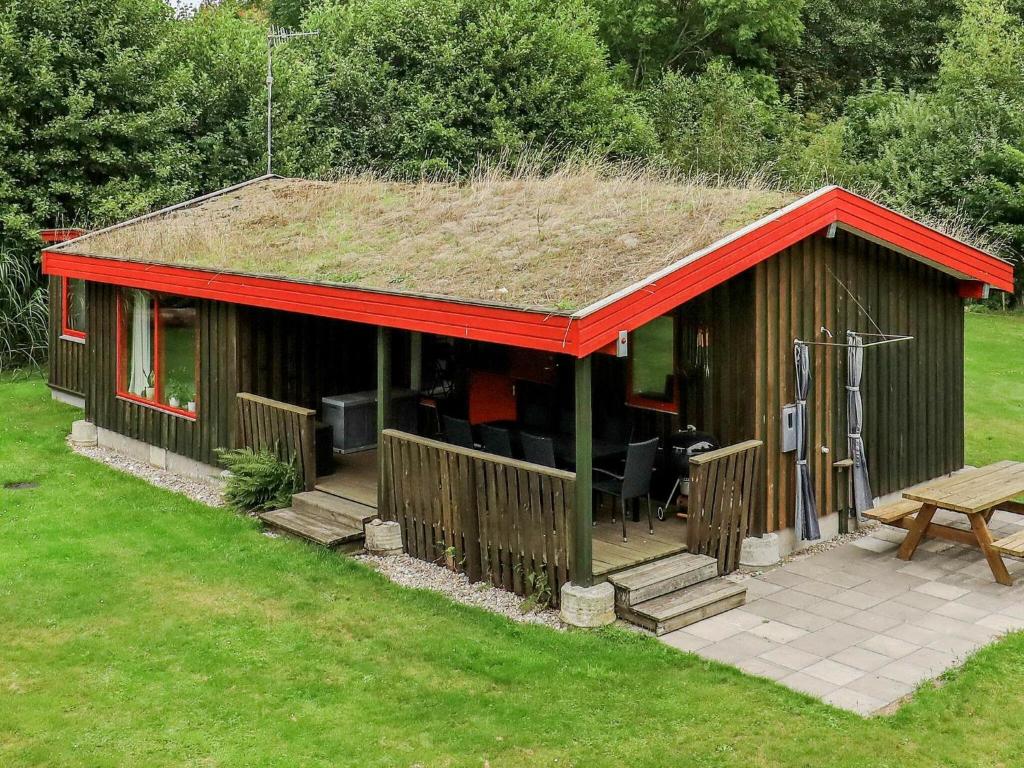 a small house with a grass roof with a patio at Holiday home Læsø XXV in Læsø