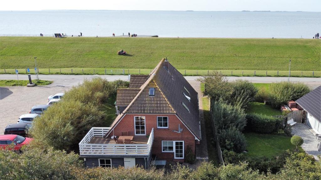 uma casa com vista para um campo e para o oceano em Deichkrone em Dagebüll