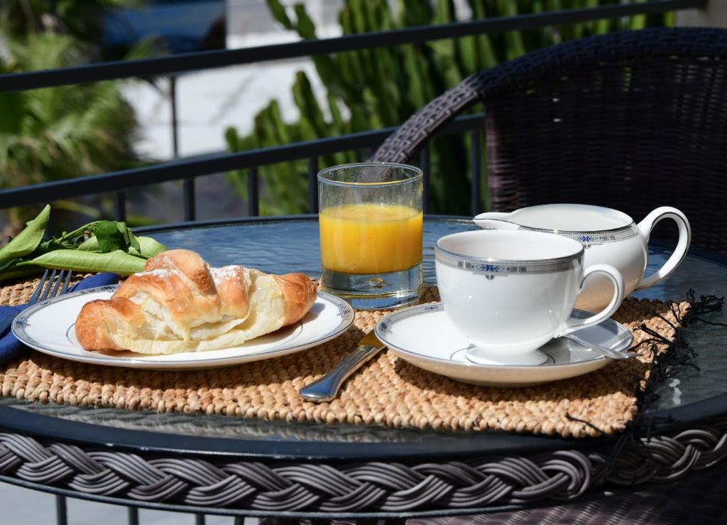 a table with a breakfast of croissants and a cup of orange juice at Sole Mare in Ventimiglia