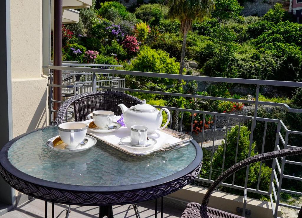 a table with two cups and saucers on a balcony at Sole Mare in Ventimiglia