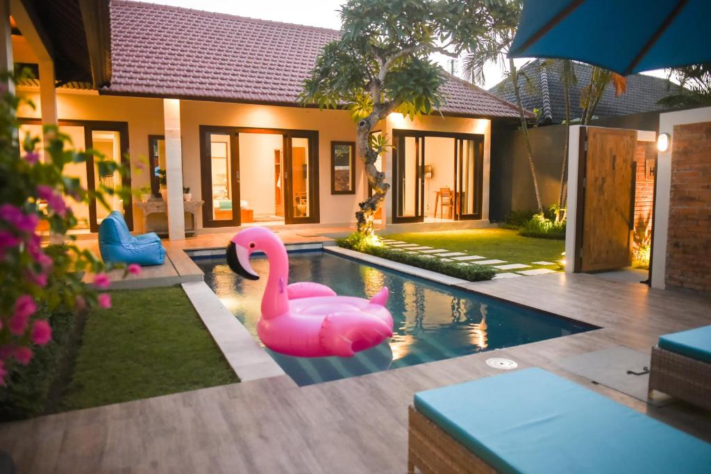 zwei rosa Flamingos in einem Pool vor einem Haus in der Unterkunft Haneirich Bali Villa in Canggu