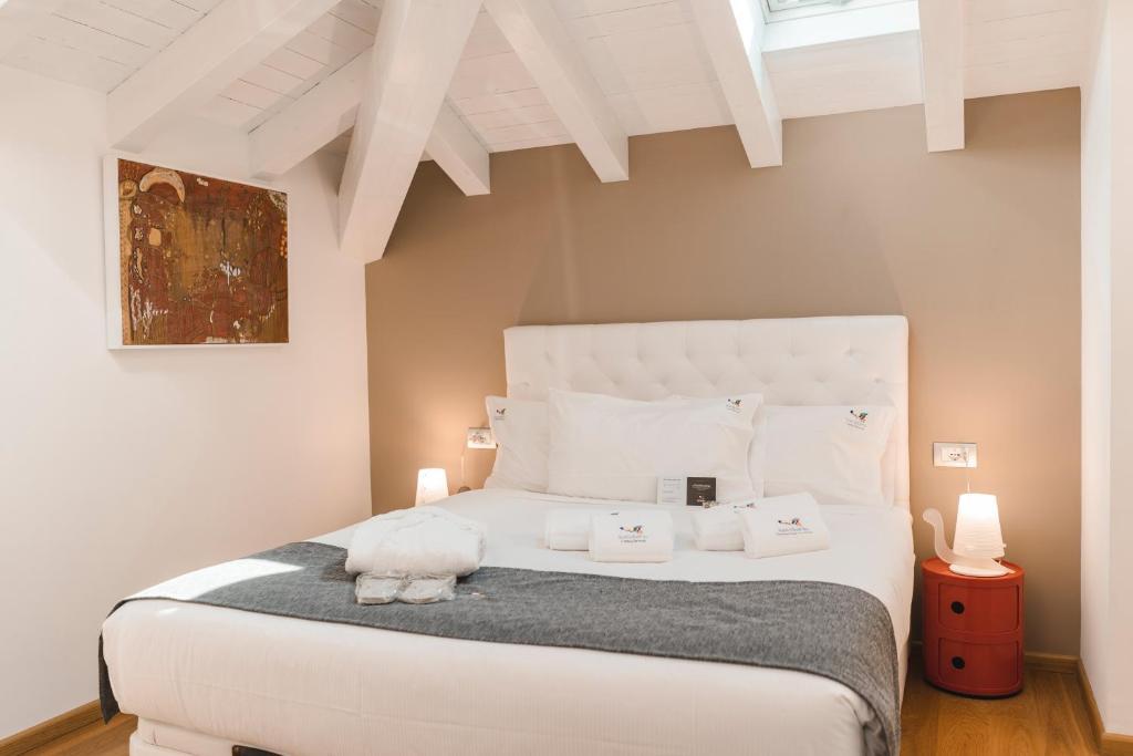 a bedroom with a white bed with a stuffed animal on it at Sicilia's Art Hotel & Spa in Acitrezza