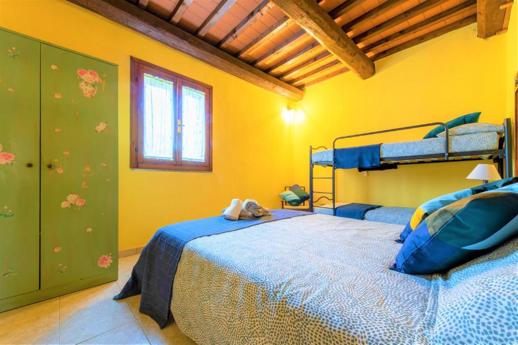 A bed or beds in a room at Hostly - Country House Donoratico - ONLY FOR FAMILIES