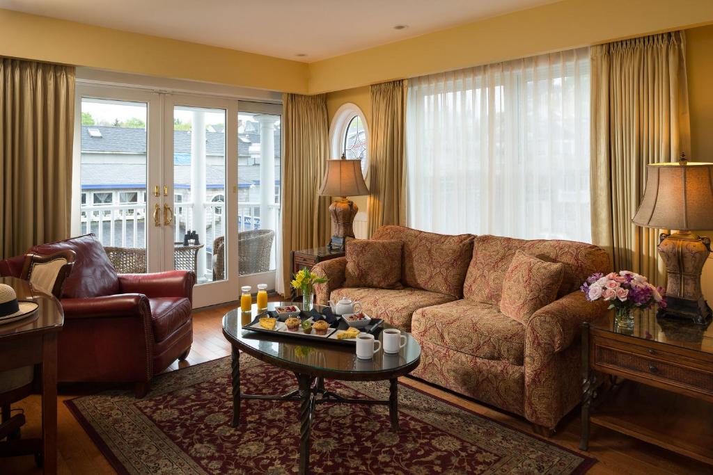 Grand Harbor Inn في كامدن: غرفة معيشة مع أريكة وطاولة