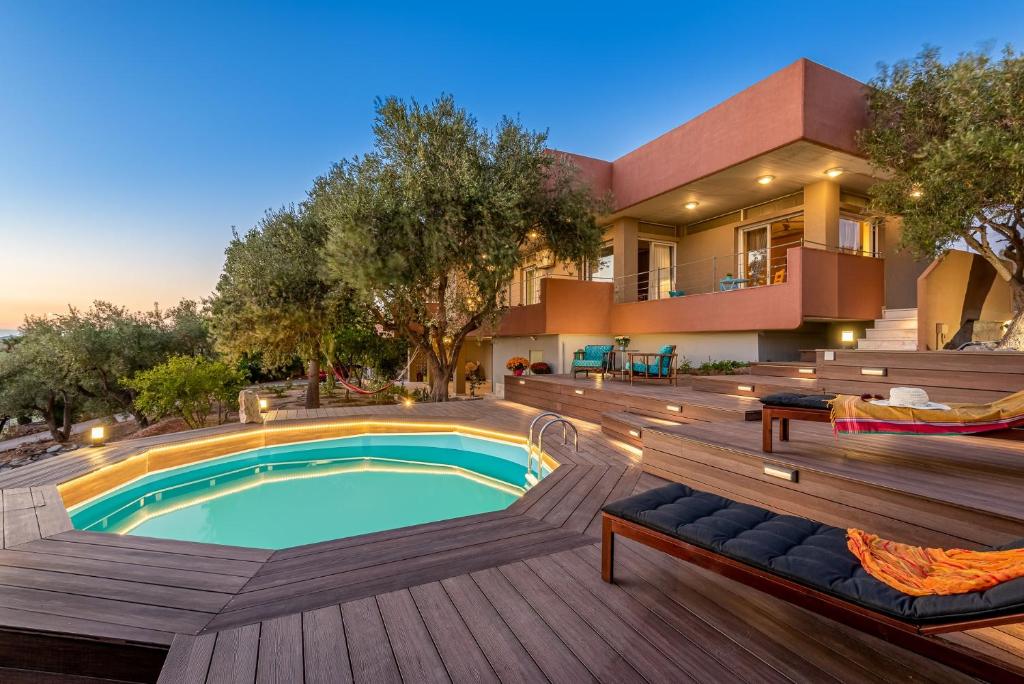 ein Haus mit einem Pool auf einer Holzterrasse in der Unterkunft Lagonisi Villa Afroditi in Lagonisi