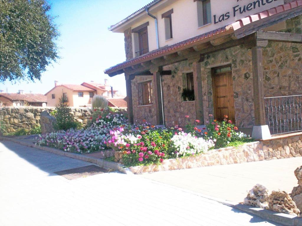 Un bâtiment avec un bouquet de fleurs devant lui dans l'établissement Hotel Las Fuentes, à Torrecaballeros
