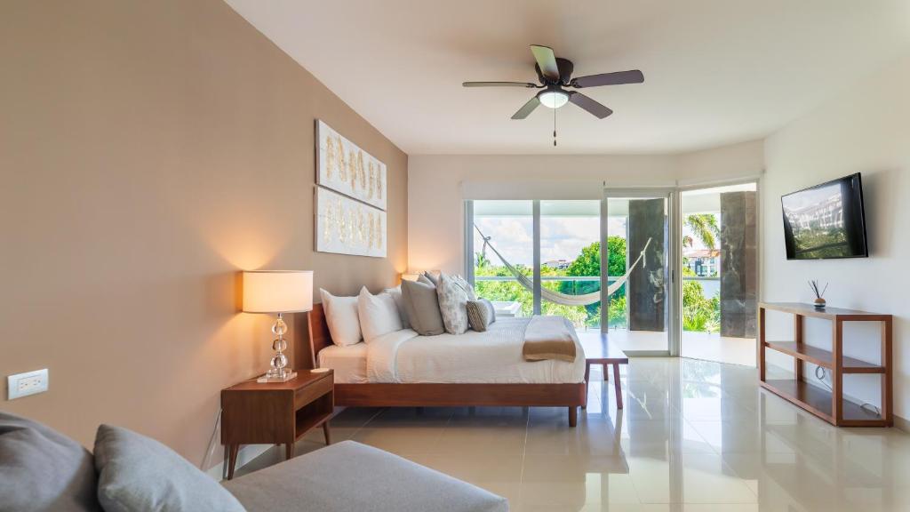 - une chambre avec un lit et un ventilateur de plafond dans l'établissement Mareazul Casa Sol norte apts, à Playa del Carmen