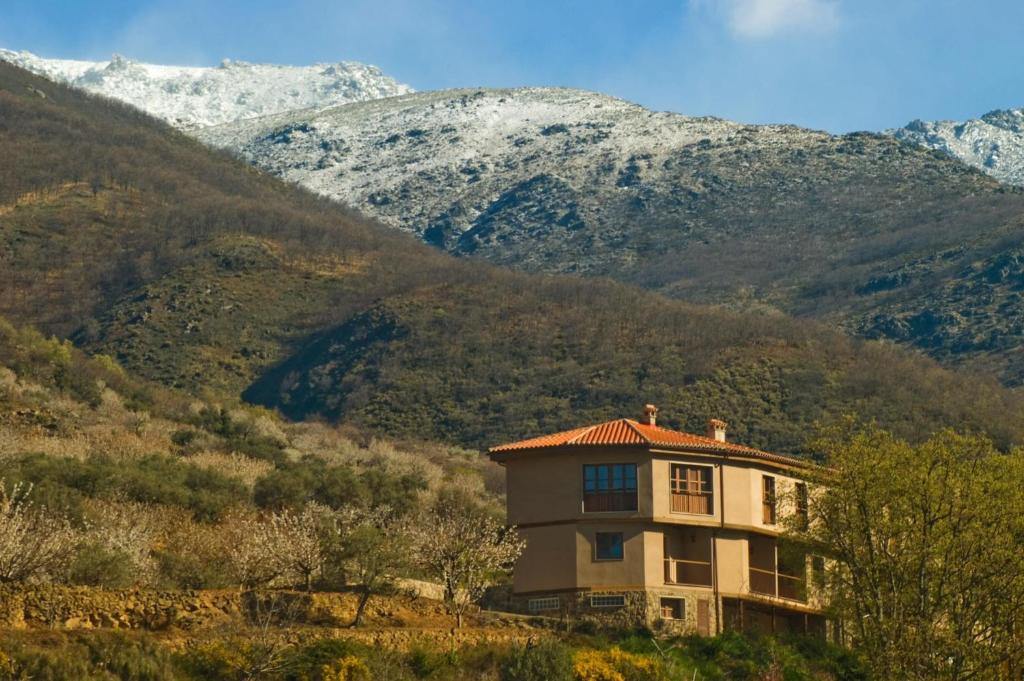 ヘルテにあるComplejo Rural Las Palomasの山を背景にした丘の上の家