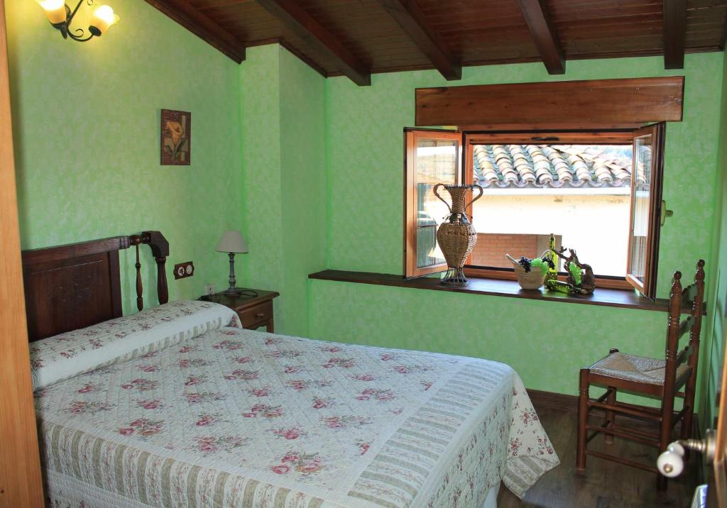 ein grünes Schlafzimmer mit einem Bett und einem Fenster in der Unterkunft Casa Rural con encanto en Las Arribes Abuelo Román in Masueco