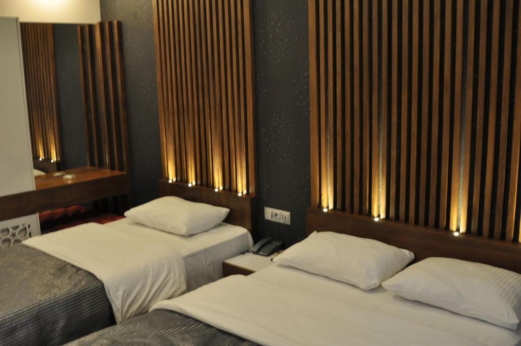 zwei Betten in einem Hotelzimmer mit zwei Betten sidx sidx in der Unterkunft ADMİRAL in Kayseri