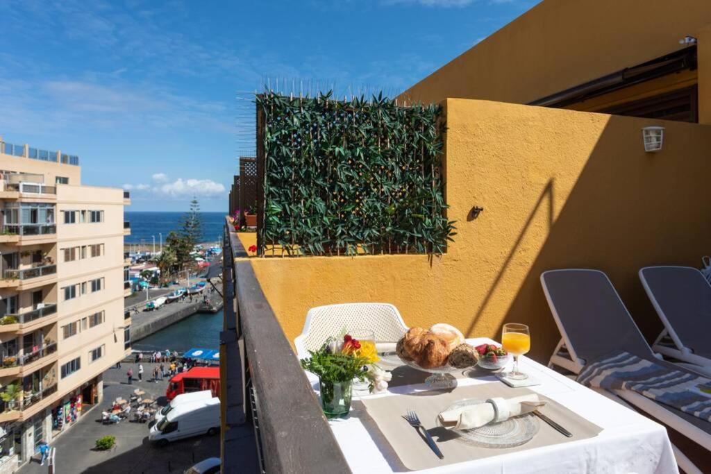 Atico junto al mar في بويرتو دي لا كروث: طاولة على جانب مبنى يحتوي على طعام