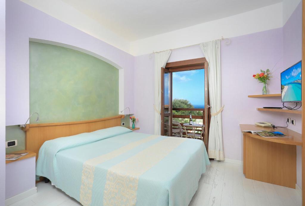 Postel nebo postele na pokoji v ubytování Hotel Cala Reale