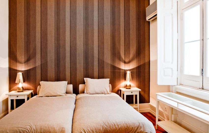 2 Betten in einem Zimmer mit 2 Lampen an 2 Tischen in der Unterkunft Gulbenkian in Lissabon