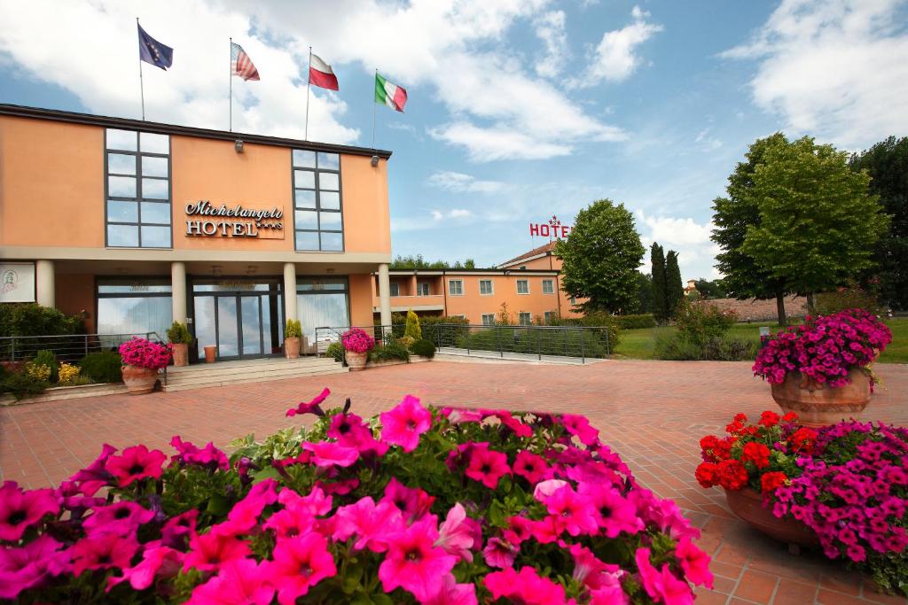 a hotel with pink flowers in front of a building at Hotel Michelangelo in Terranuova Bracciolini