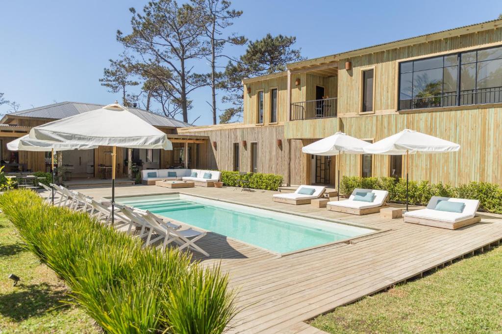 a house with a swimming pool with umbrellas at Casa Flor in Punta del Este