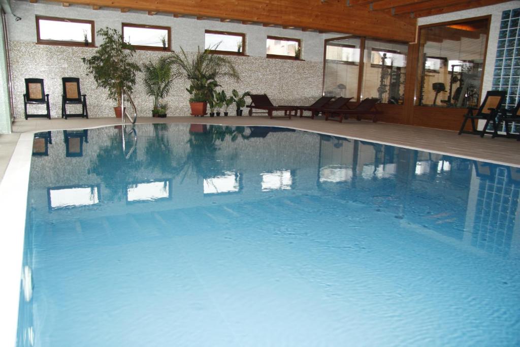 ein großer blauer Pool in einem Gebäude in der Unterkunft Wellness Penzión Rosnička in Kraľovany