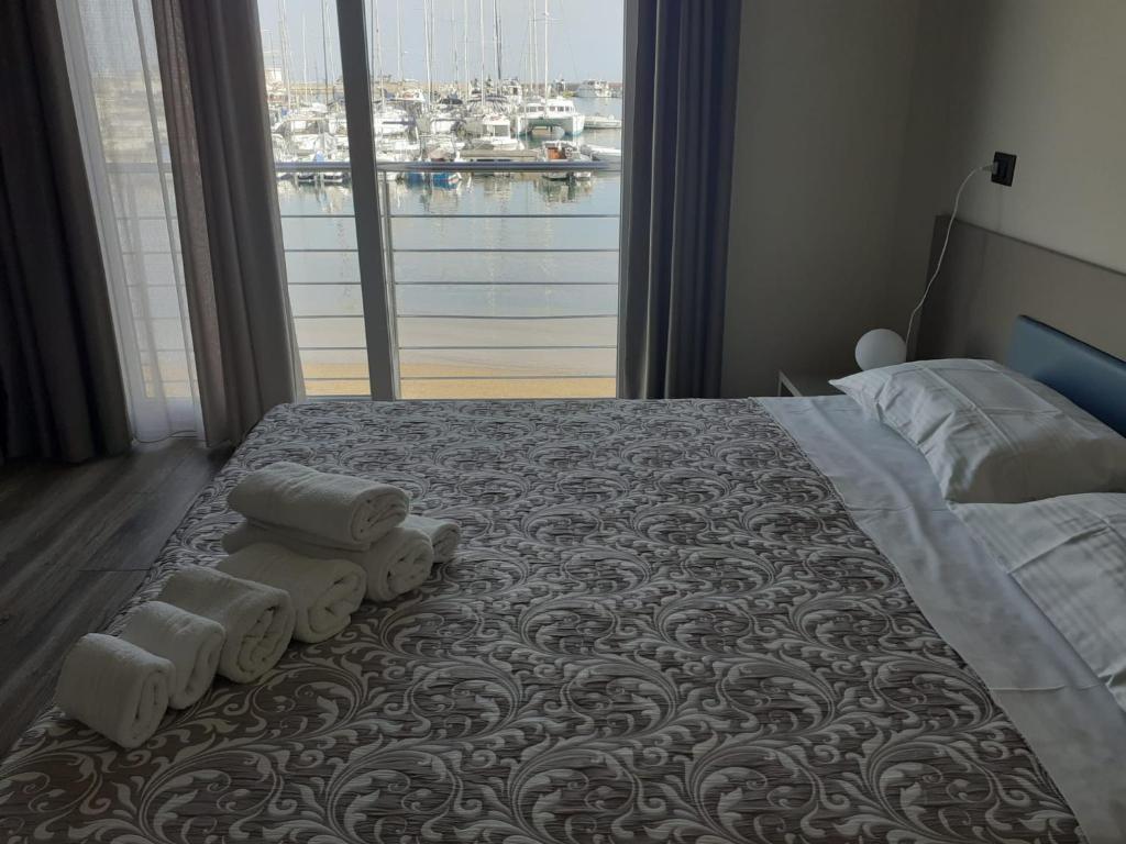ein Schlafzimmer mit einem großen Bett mit Handtüchern darauf in der Unterkunft SARACENO HOTEL in Vibo Valentia Marina