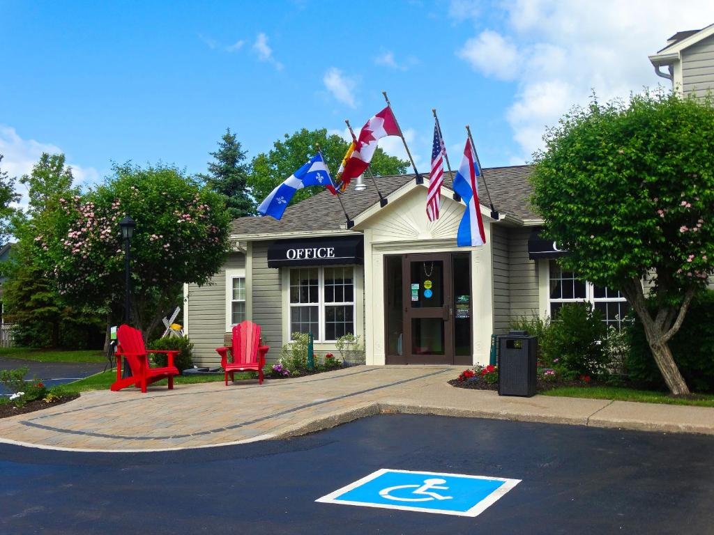 a building with flags in front of a parking lot at Amsterdam Inn & Suites Sussex in Sussex